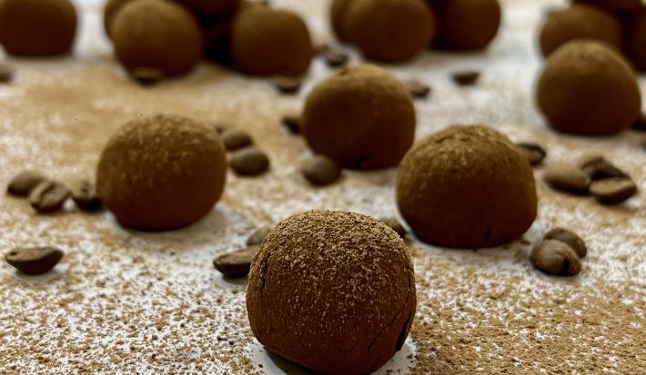 Foto da Receita de Trufa de Cappuccino. Observa-se 17 trufas dispostas sobre uma superfície com chocolate em pó polvilhado e decorada com grãos de café.