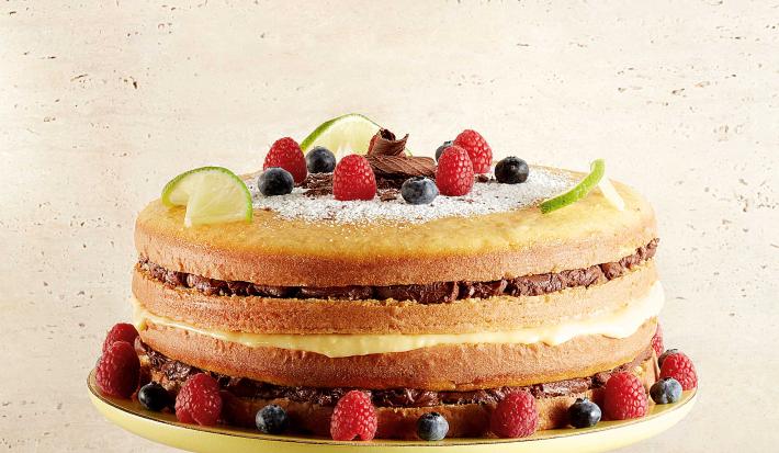 Bolo sem cobertura, com massa de limão com varias camadas de recheios e frutas vermelhas para decorar