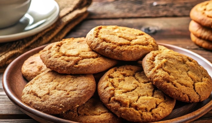 Em cima de uma mesa, prato redondo com biscoitos redondos crocantes.