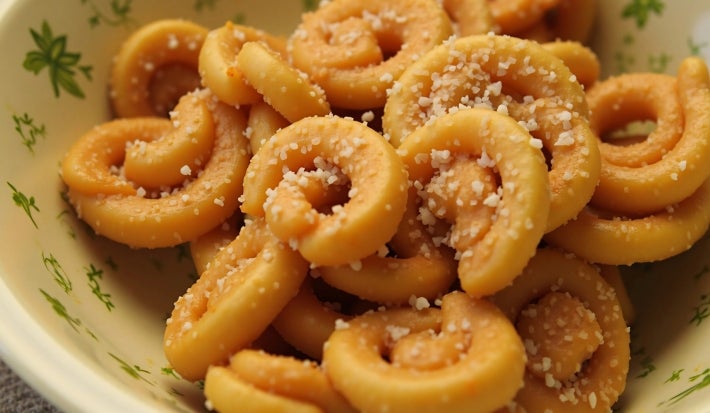 Recipiente redondo com biscoitos em meia lua e crocantes.
