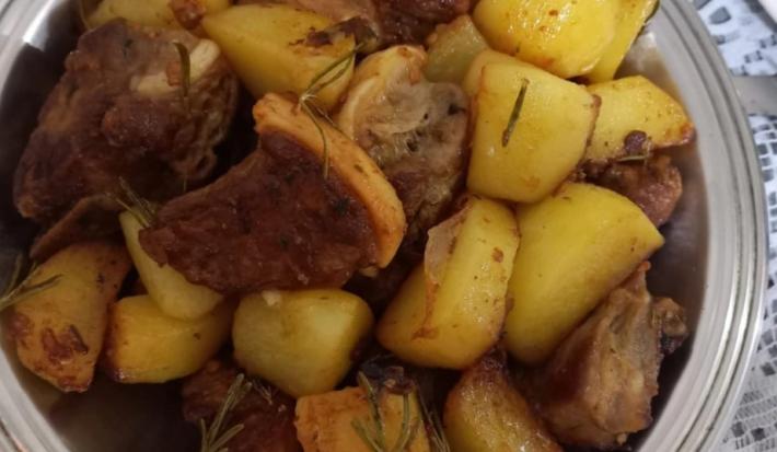 Foto da Receita de Costelinha de Porco com Batatas Salteadas no Alecrim. Observa-se um prato grande de servir de alumínio com as costelinhas e as batatas dispostas.
