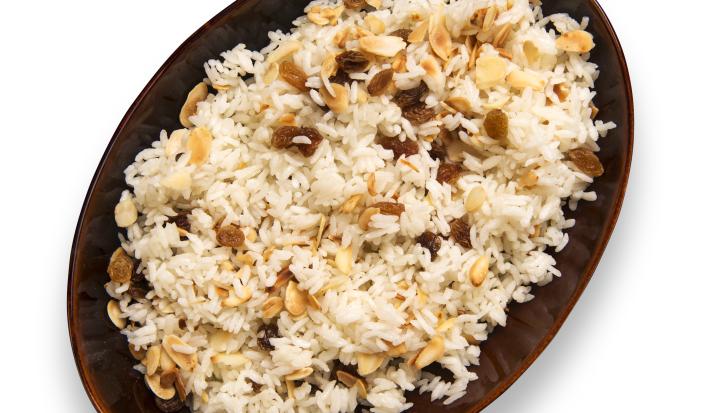 fotografia em tons de branco e marrom tirada de um recipiente oval marrom com arroz