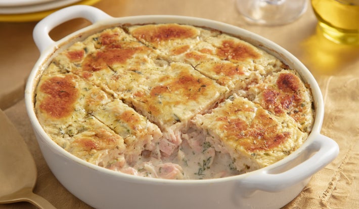 Caçarola assada de atum e salmão em molho cremoso, com superfície dourada gratinada, servida em refratário oval branco.