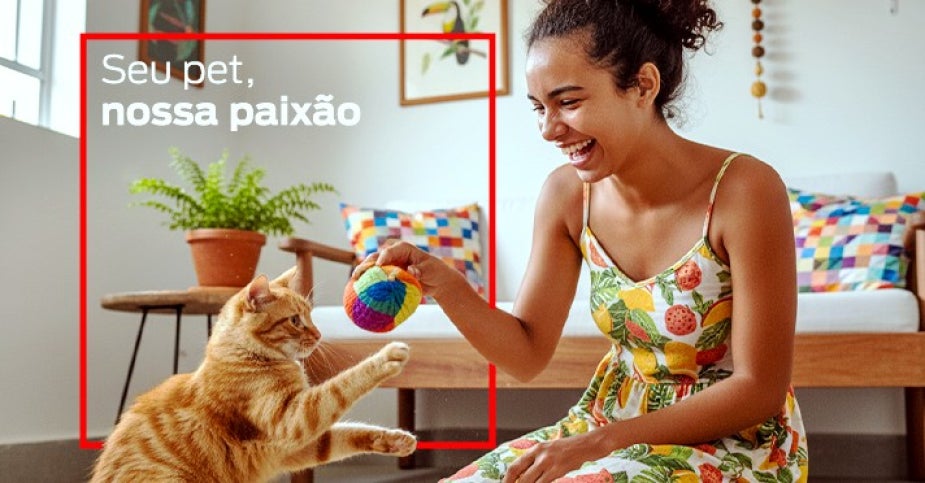 Mulher brinca com gato em casa e frase “Seu pet, nossa paixão” em destaque