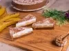 Em cima de uma mesa, fatias de banoffee com massa de biscoitos crocante, doce de leite, bananas em rodelas, decorado com chantilly cremoso, polvilhado canela em pó.