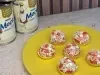 Docinhos decorados com confeitos brancos e vermelhos em formato de coração, sobre prato amarelo e com de Leite Moça ao fundo.