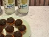 Brigadeiros cobertos com granulado de chocolate, em forminhas laranja sobre prato verde-claro, com Leite Moça ao fundo.
