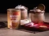 Foto da receita de cappuccino avelã servida em dois copos de vidro sobre um pano marrom