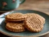 Em cima de uma mesa, prato redondo com biscoitos redondos, decorados com listas feitas com garfo.