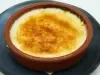 Em uma refratário redondo marrom, porção de queijo gratinado marrom.