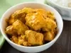 Fotografia de um frango em cubos temperado com molho de curry