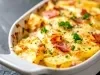 Em cima de uma mesa, refratário com batata gratinada com queijo e bacon crocante.