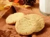 Em cima de uma mesa, pano de prato marrom com biscoitos redondos crocantes e dourados.