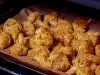 Floretes de couve-flor dourados e crocantes, servidos em uma travessa rústica com um molho cremoso ao lado.