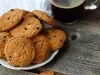 Em cima de uma mesa, prato com biscoitos em redondos crocantes e dourados.