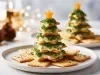 Em cima de uma mesa, prato redondo com bolachas, intercalando com as bolachas, creme branco cremoso, decorado com cheiro-verde picado e um pedaço de queijo em formado de estrela.