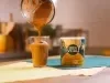 imagem mostra um copo de refresco de café cremoso, com coloração marrom e acabamento de canela