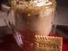Foto da receita de cappuccino caramelo salgado servida em um copo de vidro sobre uma mesa de madeira