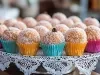 Fotografia de um apoio decorativo branco com beijinhos enrolados no coco e dentro de várias forminas coloridas.