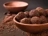 Imagem de um bowl marrom com brigadeiros feito com whey com chocolate granulado.
