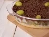 Imagem de creme branco com uvas verdes cortadas, ganache de chocolate, decorado com uvas inteiras e chocolate granulado.