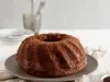 Imagem de um bolo de café redondo de furo central sobre um prato cinza.