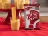 Fotografia em tons de vermelho com um prato vermelho ao centro. Em cima do prato existe uma receita de brigadeiro de maracujá de colher com vários kitkats mysterys espetados como decoração. Fotografia em tons de vermelho com um prato vermelho ao centro. Em cima do prato existe uma receita de brigadeiro de maracujá de colher com vários kitkats mysterys espetados como decoração.