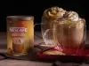 Foto da receita de cappuccino caramelo salgado servida em dois copos de vidro sobre uma mesa de madeira