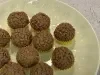 Docinhos cobertos com granulado de chocolate em prato claro, com latas de Leite Moça ao fundo.