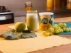 imagem mostra um copo de suco verde cremoso, servido gelado e decorado com folhas de hortelã