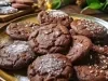 Em cima de uma mesa, prato com biscoitos de chocolate, polvilhados com açúcar de confeiteiro.