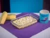 Fotografia em tons amarelo e roxo com uma travessa de vidro ao centro. Na travessa, existe uma receita de Fricassê de frango feita com Ascenda e finalizada com queijo branco.