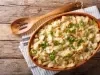 Bacalhau com natas gratinado em refratário oval, coberto com queijo dourado e cebolinha picada.