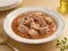 Goulash moderno de atum servido em prato fundo, com cubos de peixe em molho de tomate encorpado e ervas frescas.