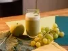imagem mostra um copo de suco verde cremoso, servido gelado e decorado com folhas de hortelã