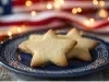 Em cima de uma mesa, prato azul redondo com biscoitos em formato de estrelas.