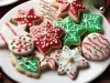 Em cima de uma mesa, prato branco com biscoitos em formato de estrelas e círculos, decorados com glacê colorido e confeitos coloridos.