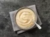 Fotografia mostrau ma tigela branca com mingau de fubá cremoso.