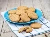 Em cima de uma mesa, prato redondo com porção de biscoitos redondos e crocantes.