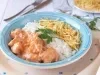 Imagem de um prato azul claro com strogonoff de frango, arroz branco e batata palha decorado com uma folha de salsa.