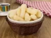 Em cima de uma mesa, tigela com biscoitos de polvilho crocantes e dourados.