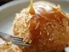 Em um garfo, bala redonda de caramelo crocante.
