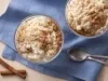 Foto tirada de cima de dois potes de vidro com arroz dentro e decorados com canela em pó em cima de um pano azul