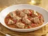 Goulash moderno de atum servido em prato fundo, com cubos de peixe em molho de tomate encorpado e ervas frescas.