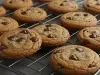 Em cima de uma mesa, uma grade com biscoitos com gotas de chocolate.