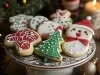 Em cima de uma mesa, prato com biscoitos formato de boneco de neve e árvore de Natal, decorado com glacê colorido e confeitos brancos.