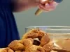 Rosquinhas fit de banana e aveia, assadas e empilhadas com cobertura de Nutren chocolate ao fundo