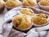 Em cima de uma mesa, enrolado em um pano de prato bolinhos de laranja dourados.