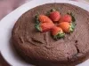 Foto da receita inteira de bolo cremoso de aveia servido sobre um prato disforme branco em cima de um pano cor de rosa