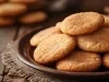 Em cima de uma mesa, biscoitos redondo crocantes e dourados.